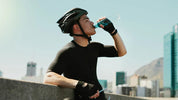 A biker drinks a blue electrolyte drink to rehydrate, showing the concept of the link between electrolytes and immune health.