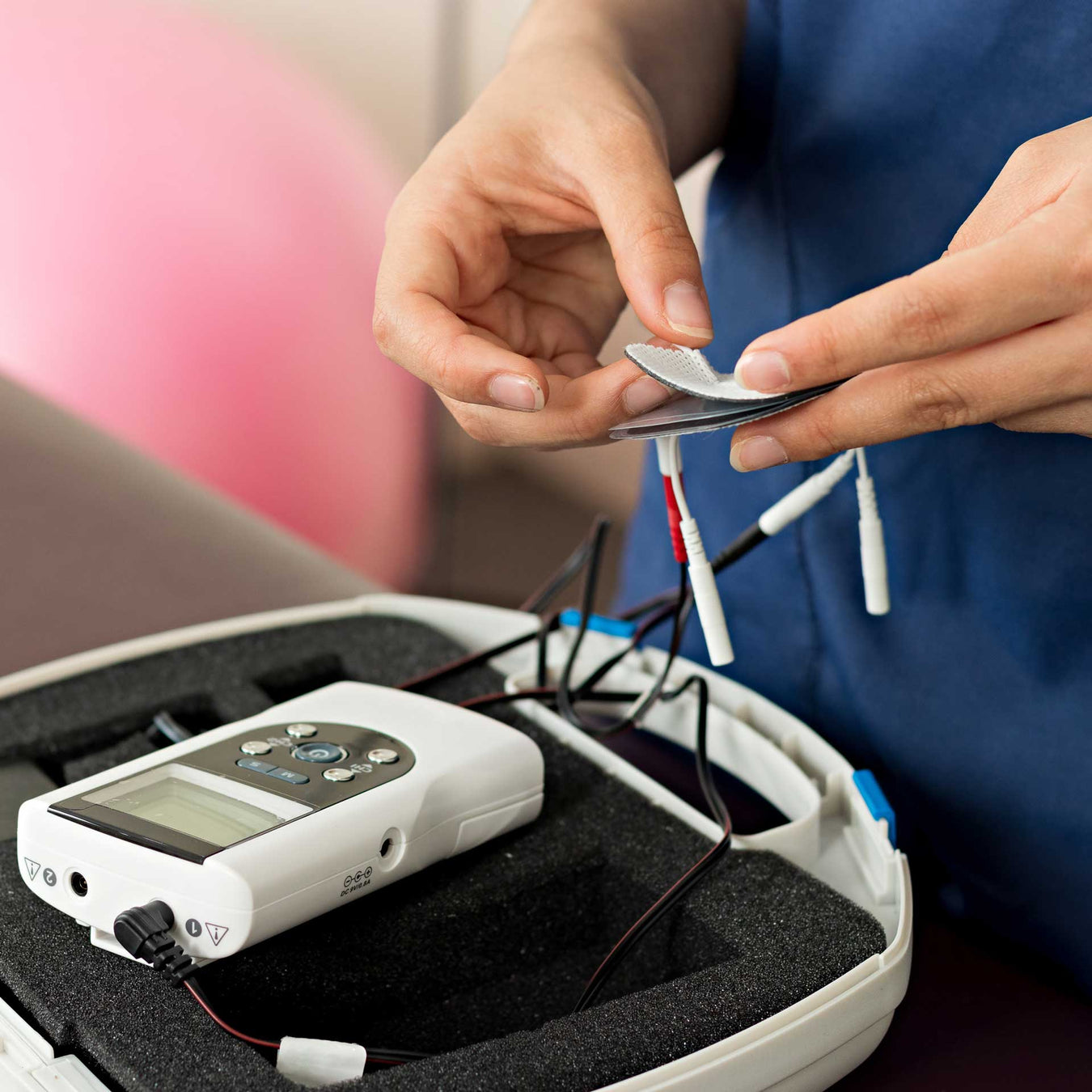 clinician setting up an electrotherapy STIM unit for physical therapy