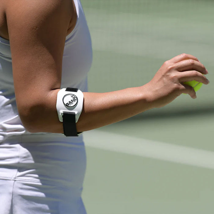 Woman tennis player playing tennis while wearing the ProBand BandIT on her forearm
