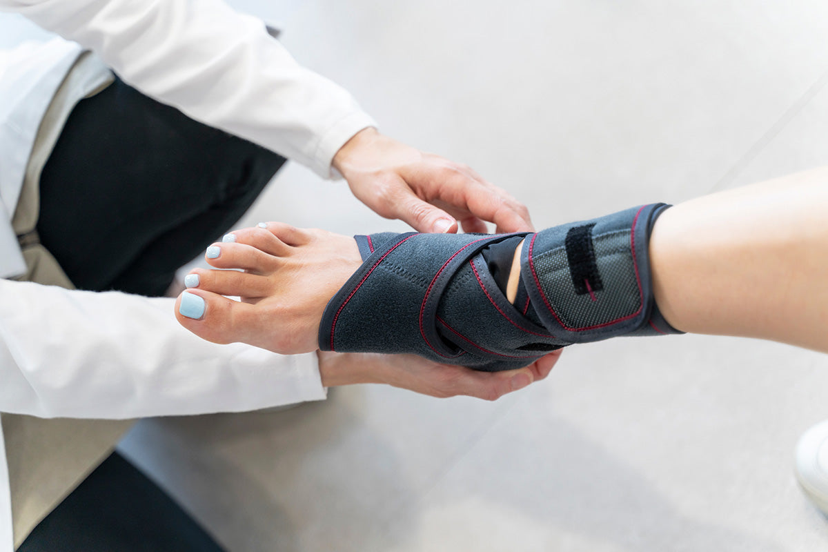 A doctor putting an ankle brace on someone's leg