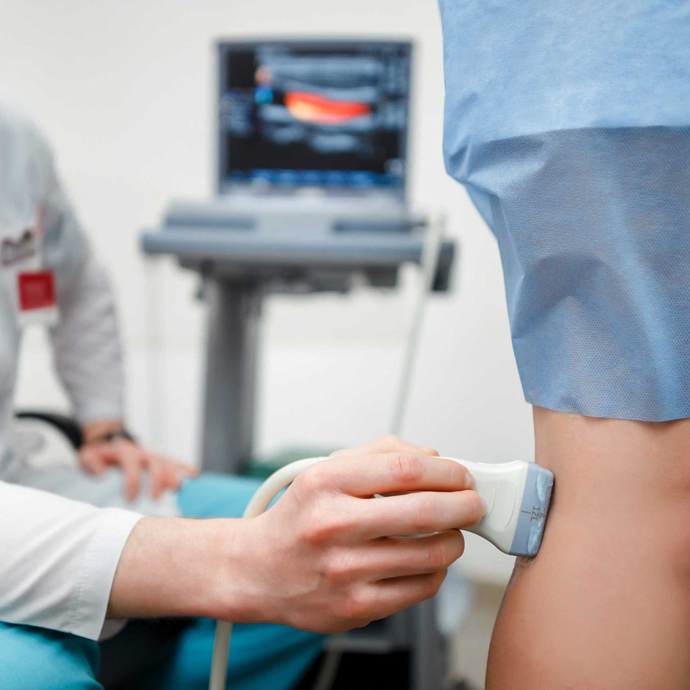 physical therapist using ultrasound therapy to treat patient's leg pain