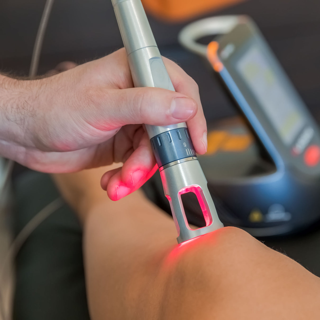 physical therapist uses laser therapy to address patient's knee pain