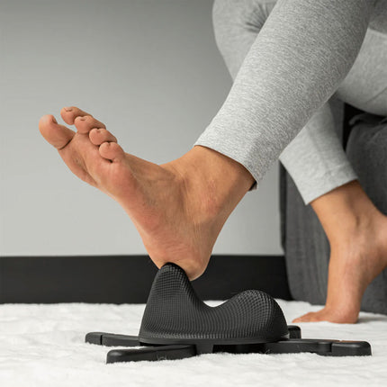 woman using the Alleviate Arch Massager to massager the heel of her foot