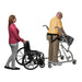 elderly man using the Biodex Rehab Mobility Assist to walk while a woman follows with his wheelchair