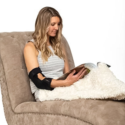 woman reading a book in a lounge chair while wearing the Hely & Weber GELrod Elbow