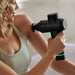 woman using the Hyperice Hypervolt 2 Portable Massage Gun to massage her shoulder
