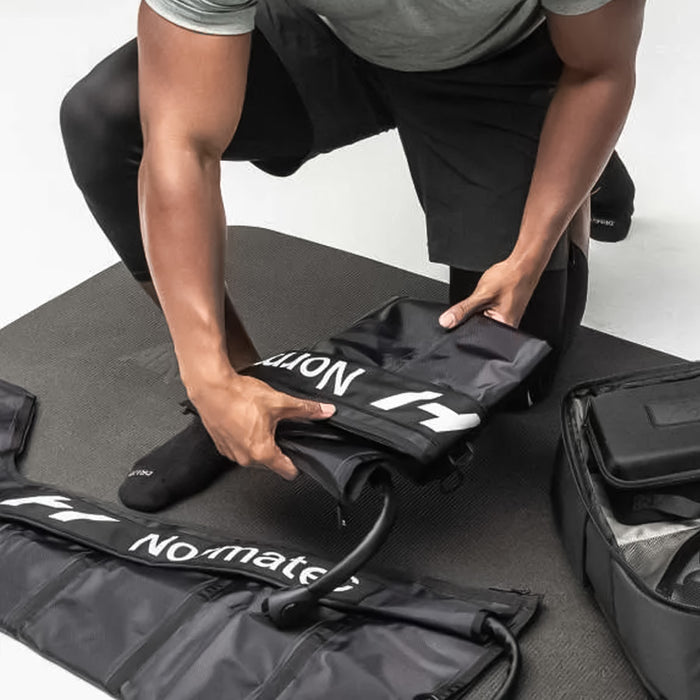 man unfolding the Hyperice Normatec 3 Legs Air Compression Boots