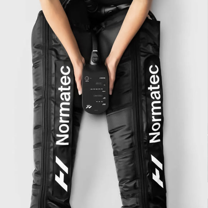 woman using both Hyperice Normatec 3 Legs Air Compression Boots on her legs