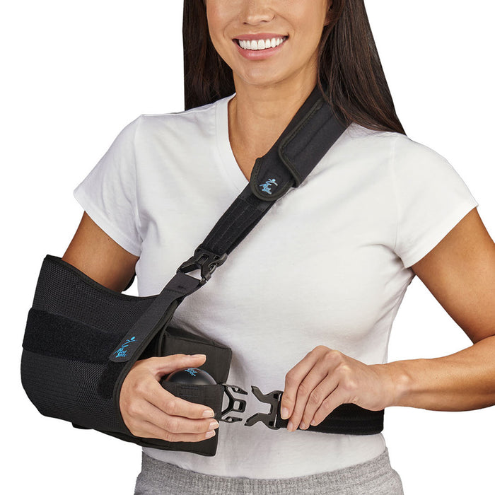 woman adjusting the waist strap on the Med Spec Outrigger II Shoulder Immobilizer