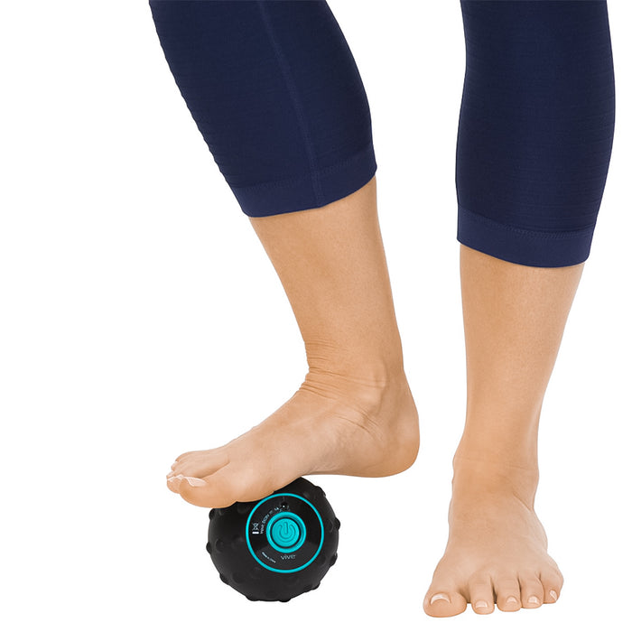 woman using the Vive Health Vibrating Massage Ball to massage her foot