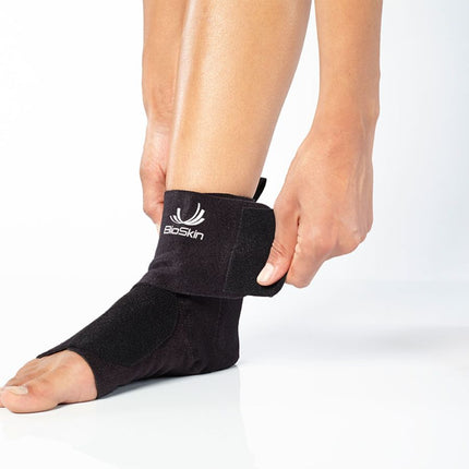 person adjusting BioSkin Premium Ankle Compression Brace 