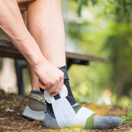 person adjusting BioSkin TriLok Ankle Brace