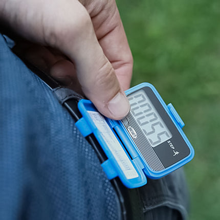 person checking their daily steps on the digital display of the Baseline Lite Pedometer