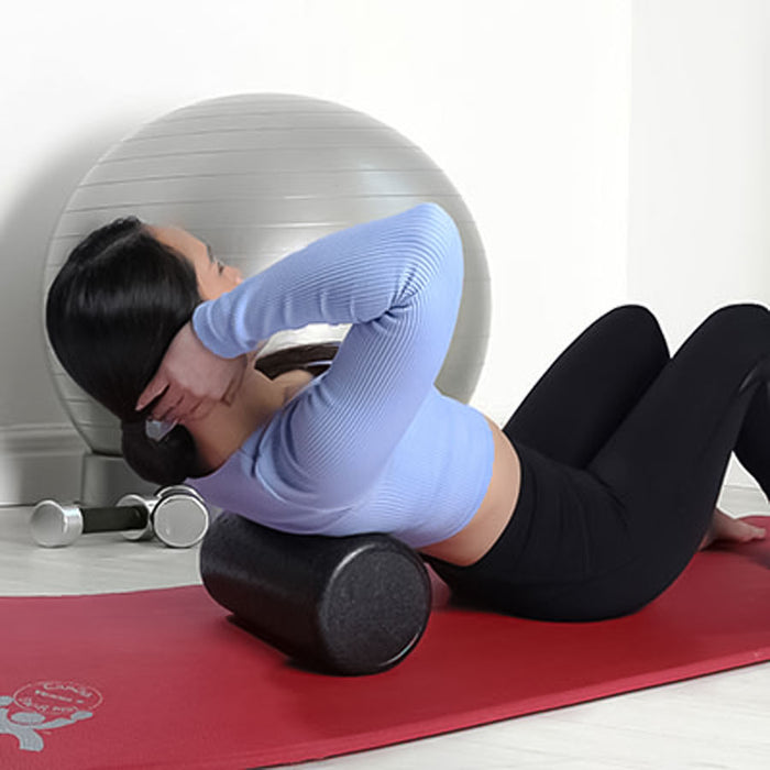 Woman using CanDo Composite Foam Roller Extra-Firm for elevated crunches