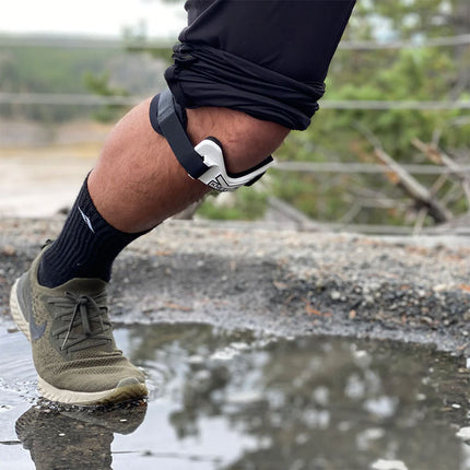 man soccer player wearing the ProBand KneedIT below his knee while outside